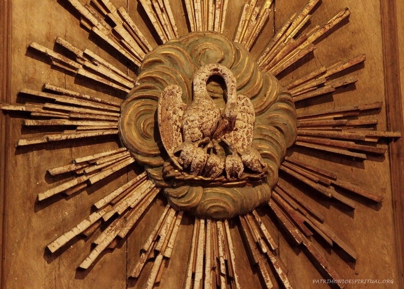 Figura do pelicano. Na Antiguidade acreditava-se que este animal, quando não conseguia obter comida para os filhotes, tirava de sua própria carne para alimentá-los. Tal simbologia ficou aplicada a Cristo, que alimenta os cristãos com a Eucaristia.