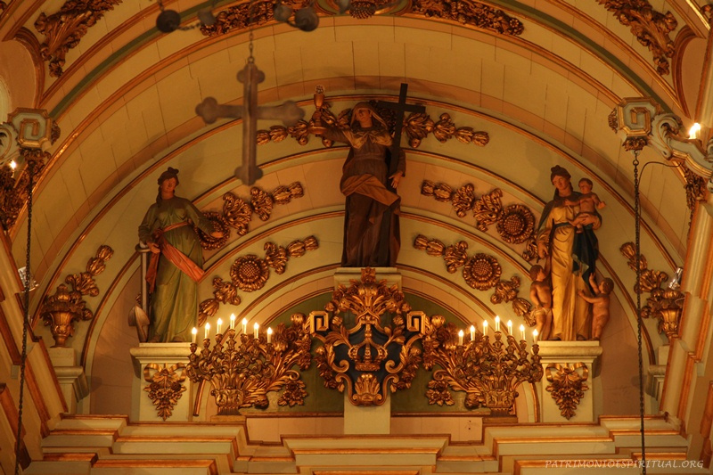 No alto do altar-mor, imagens figurativas representando as três virtudes teologais: a Esperança (esquerda), a Fé (no centro), e a Caridade (direita)